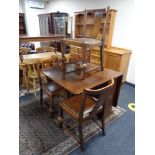 A 1930's oak drop leaf table and three chairs
