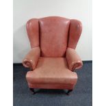 A red leather wing backed armchair