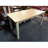 A contemporary oak topped pull out table on painted legs