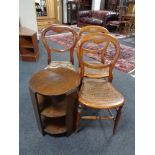 A circular oak three tier book table together with three bedroom chairs