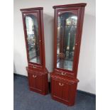 A pair of mahogany effect corner display cabinets fitted with cupboards and drawers