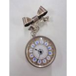 A silver fob watch together with a silver bow brooch