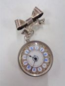 A silver fob watch together with a silver bow brooch