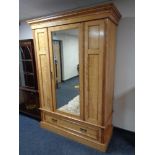 An Edwardian satinwood mirrored door wardrobe fitted with drawer beneath