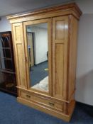 An Edwardian satinwood mirrored door wardrobe fitted with drawer beneath