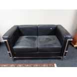 A contemporary metal framed black leather two seater settee