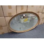 An early 20th century oval gilt framed bevelled edge mirror