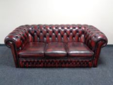 A three seater Chesterfield style oxblood leather club settee CONDITION REPORT: