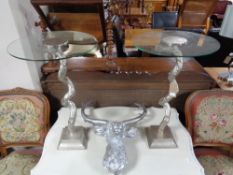 A pair of contemporary glass topped wine tables on twist columns together with a stag head wall