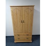 A pine effect double door child's wadrobe fitted with two drawers