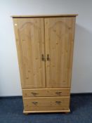 A pine effect double door child's wadrobe fitted with two drawers