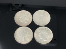 Four American silver dollars