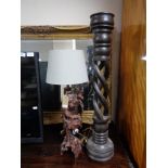 A carved hardwood table lamp with shade depicting a man,