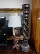 A carved hardwood table lamp with shade depicting a man,