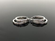 A pair of silver and diamond hoop earrings