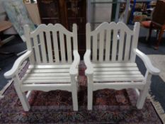 A pair of painted wooden garden armchairs