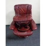 A maroon leather Stressless swivel adjustable armchair with stool