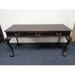 A reproduction mahogany three drawer hall table on claw and ball feet 155 cm wide,