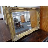 An ornate Victorian style gilt framed overmantel mirror 112 cm x 81 cm.
