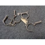 Two pairs of antique hand cuffs (one with key)
