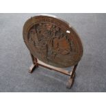 A carved oriental hardwood folding occasional table