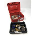 A cash tin with key containing two silver brooches, silver fob, cuff links and costume jewellery,