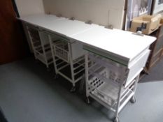 Three metal medical trolleys with trays and baskets