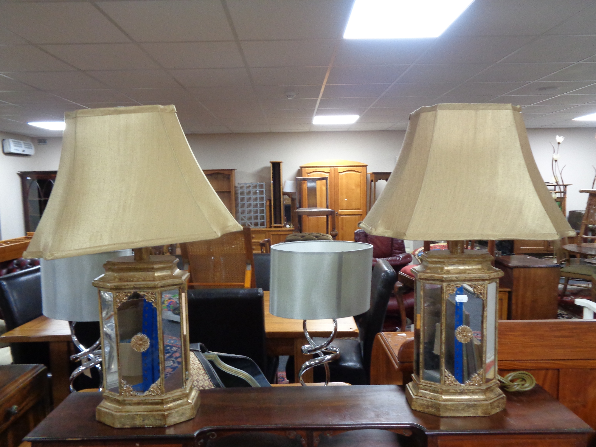 A pair of contemporary gilt mirrored table lamps with shades