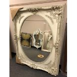 A large white oval panel mirror