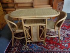 A bamboo and wicker table with two stow-away chairs