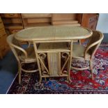 A bamboo and wicker table with two stow-away chairs