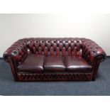 A three seater Chesterfield style oxblood leather club settee CONDITION REPORT: