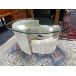 A contemporary glass topped coffee table on stone effect base