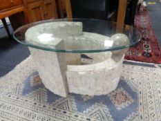 A contemporary glass topped coffee table on stone effect base