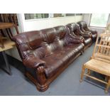 A three piece brown leather lounge suite with wooden frame