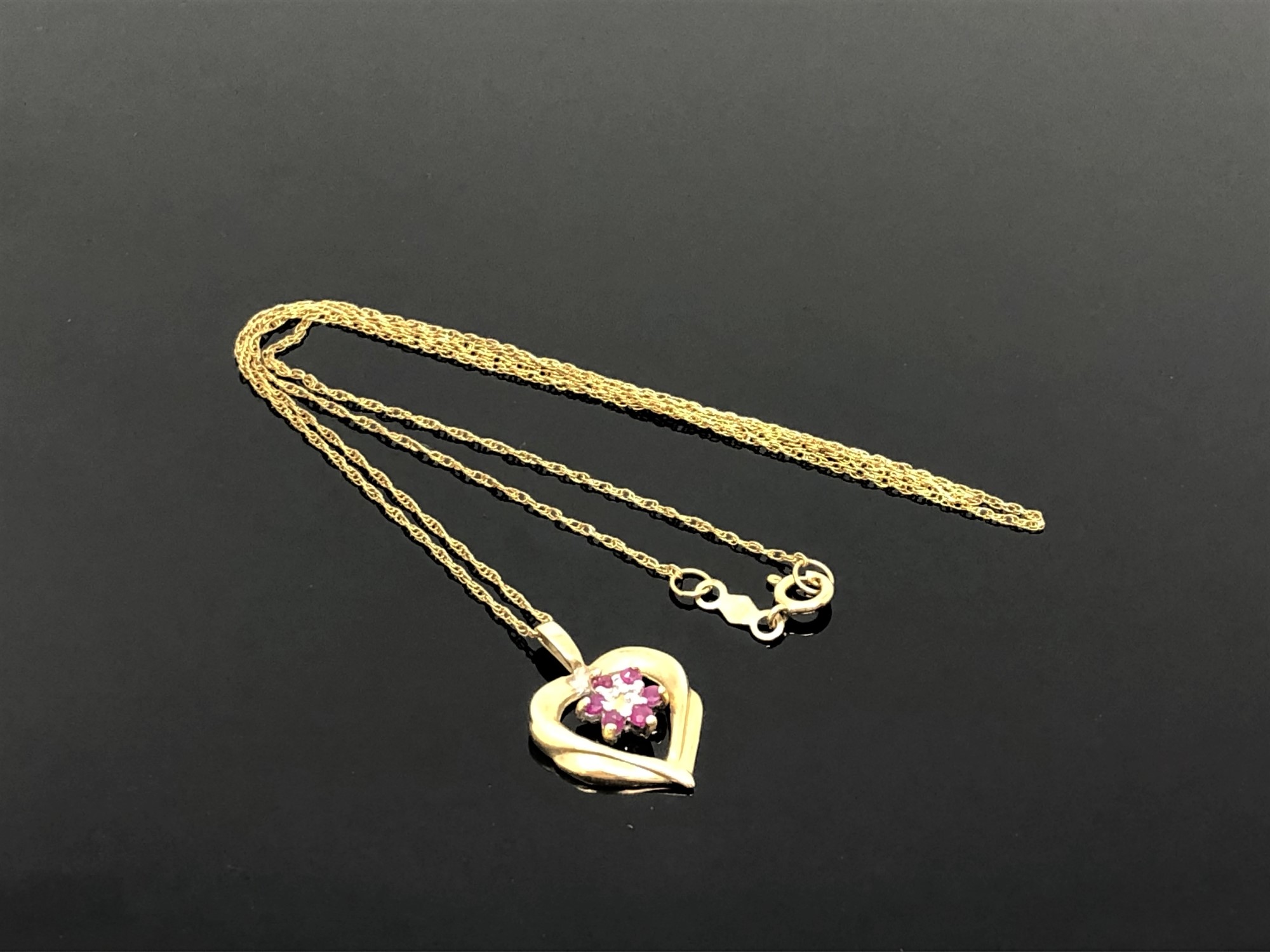 A 10ct gold ruby set heart pendant on chain