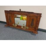 An Edwardian oak overmantel mirror with brass candle sconces