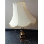 A brass table lamp with tasseled shade