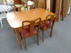 A 20th century teak extending dining table and four walnut chairs