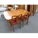 A 20th century teak extending dining table and four walnut chairs