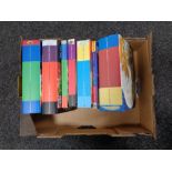 A box of seven Harry Potter hardback and paper backed volumes