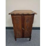An oak double door cabinet with barley twist column supports