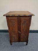 An oak double door cabinet with barley twist column supports