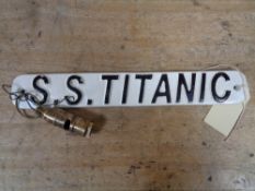 A metal plaque - SS Titanic together with a whistle