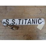 A metal plaque - SS Titanic together with a whistle