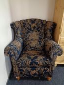 A wingback armchair in blue and gold classical print