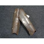 A pair of antique metal shin guards