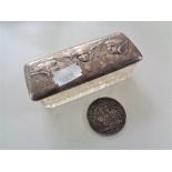 A silver topped dressing table pot depicting three cherubs together with an 1899 Victoria coin