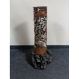 A carved Japanese hardwood floor standing vase with mother of pearl decoration