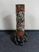 A carved Japanese hardwood floor standing vase with mother of pearl decoration